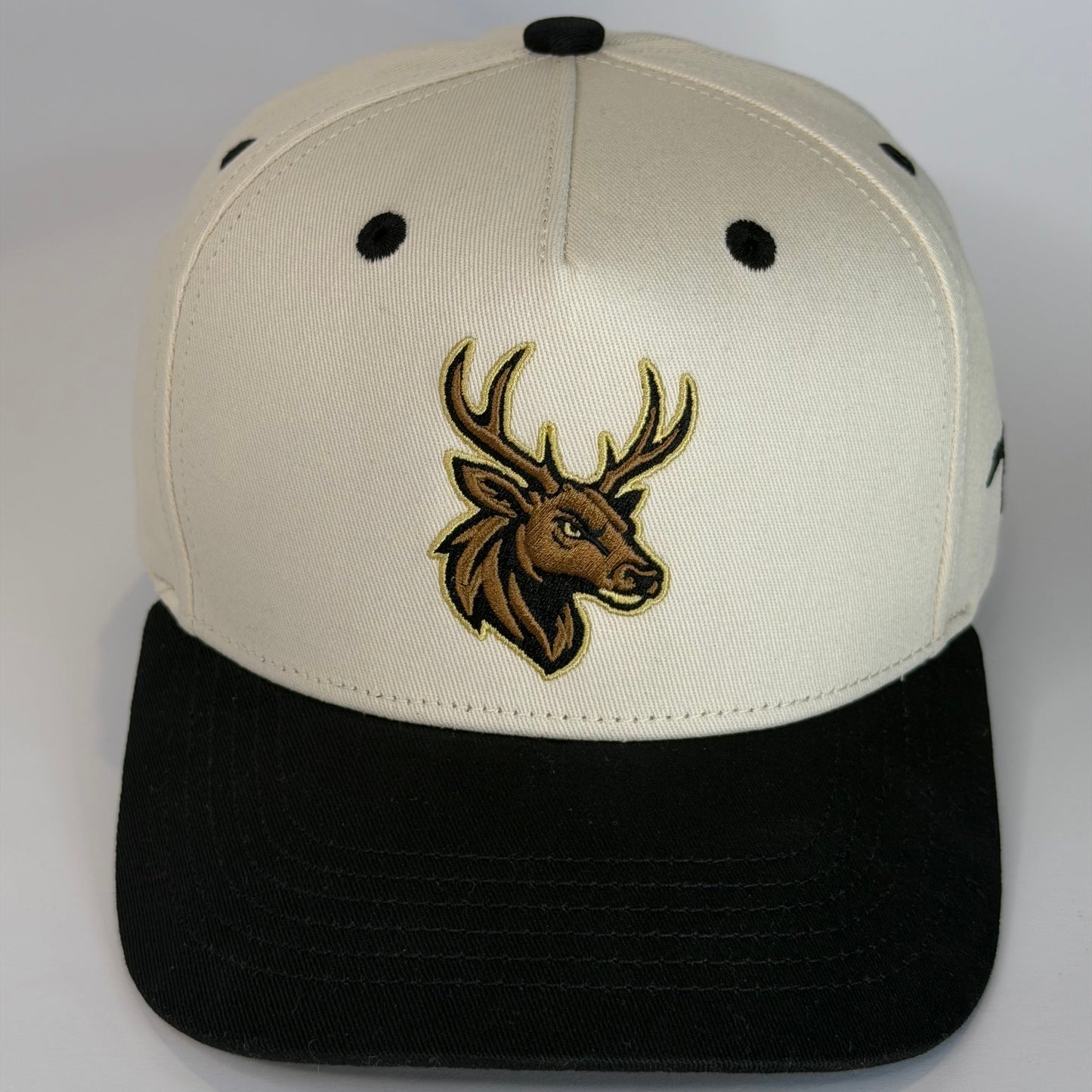 Two-toned cap with a deer logo on a light gray background