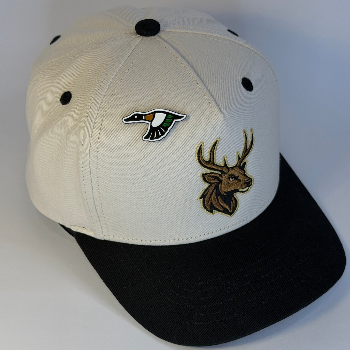 Cap with deer and duck logo pin on a white background