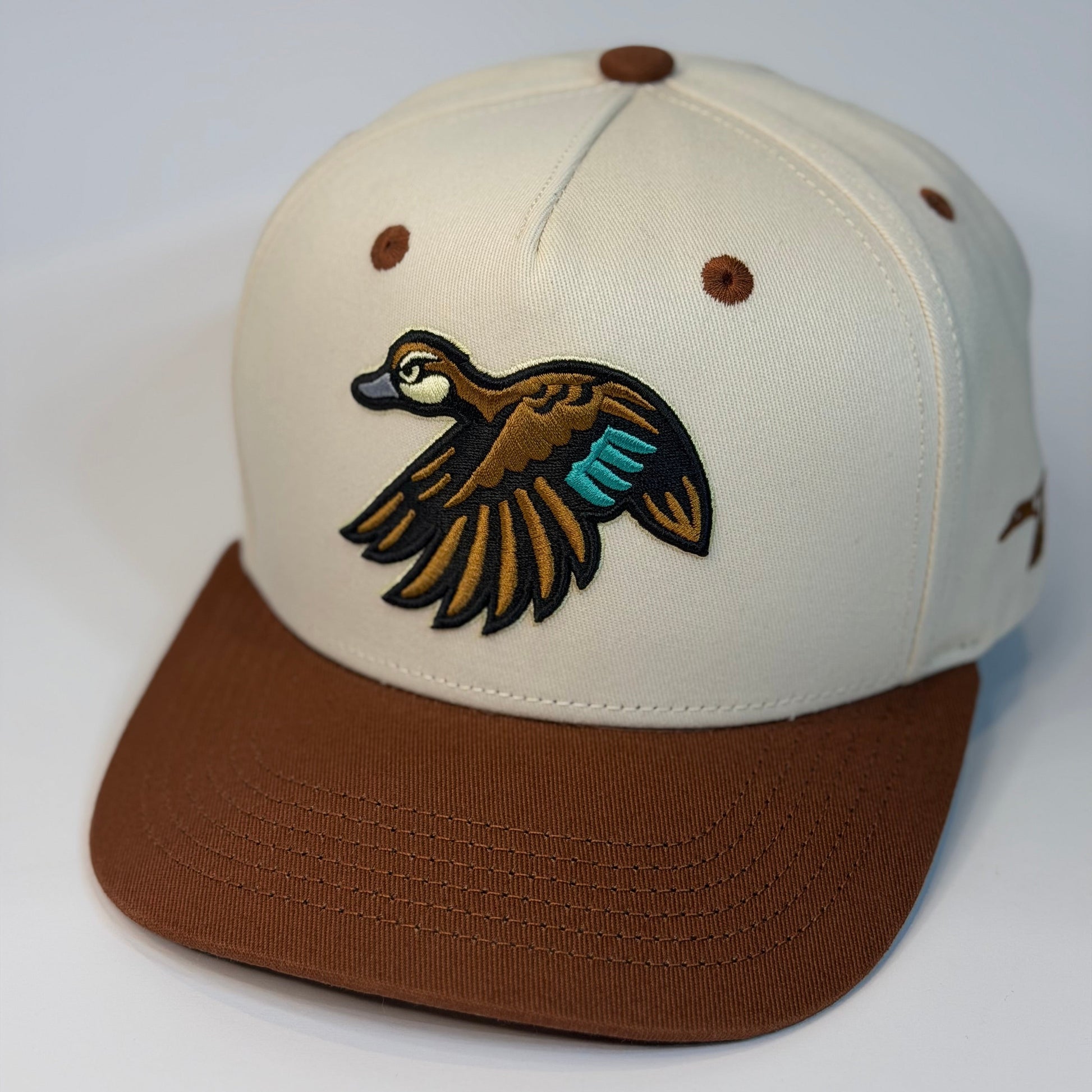 Beige and brown cap with duck logo on a white background