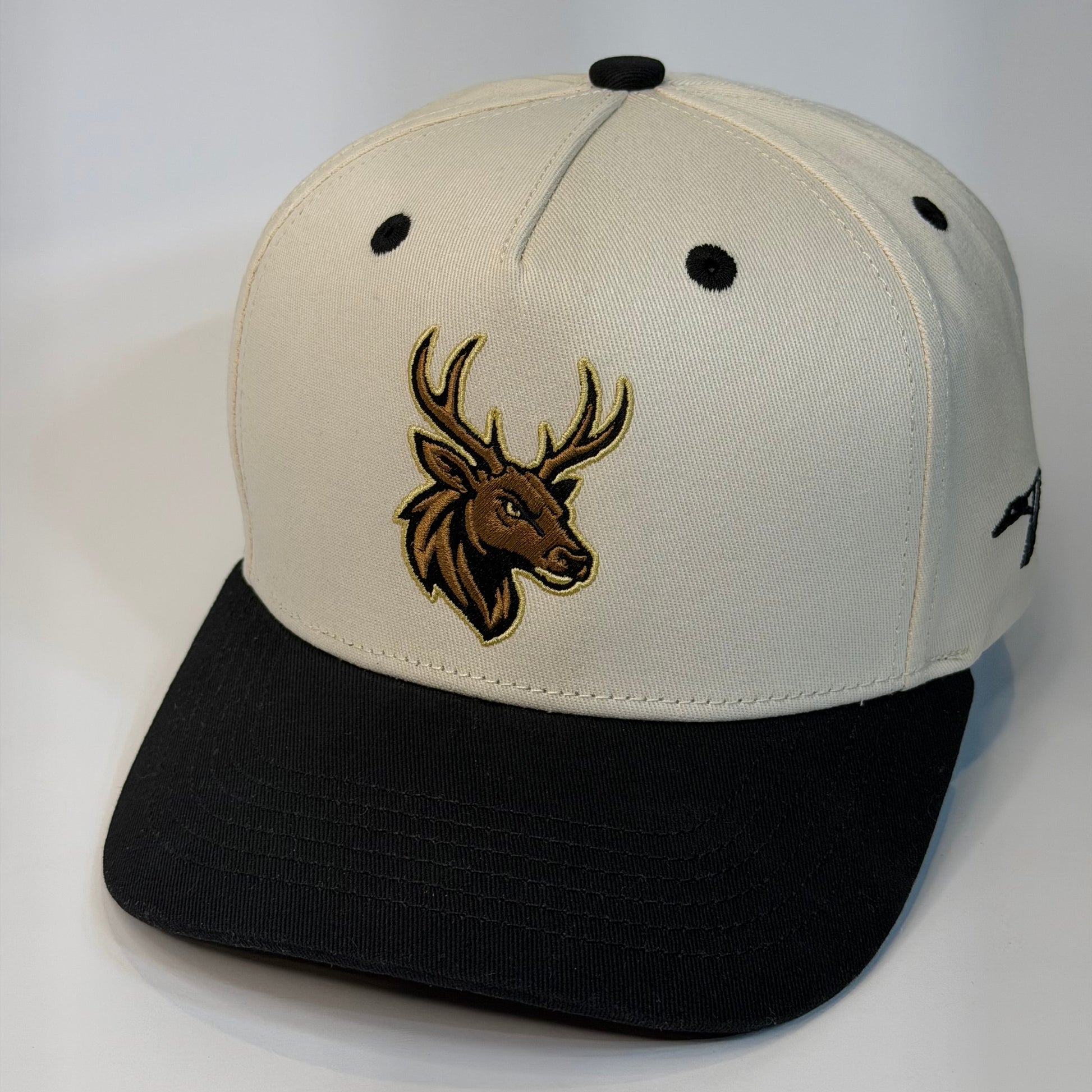 Beige and black cap with a deer emblem on a white background