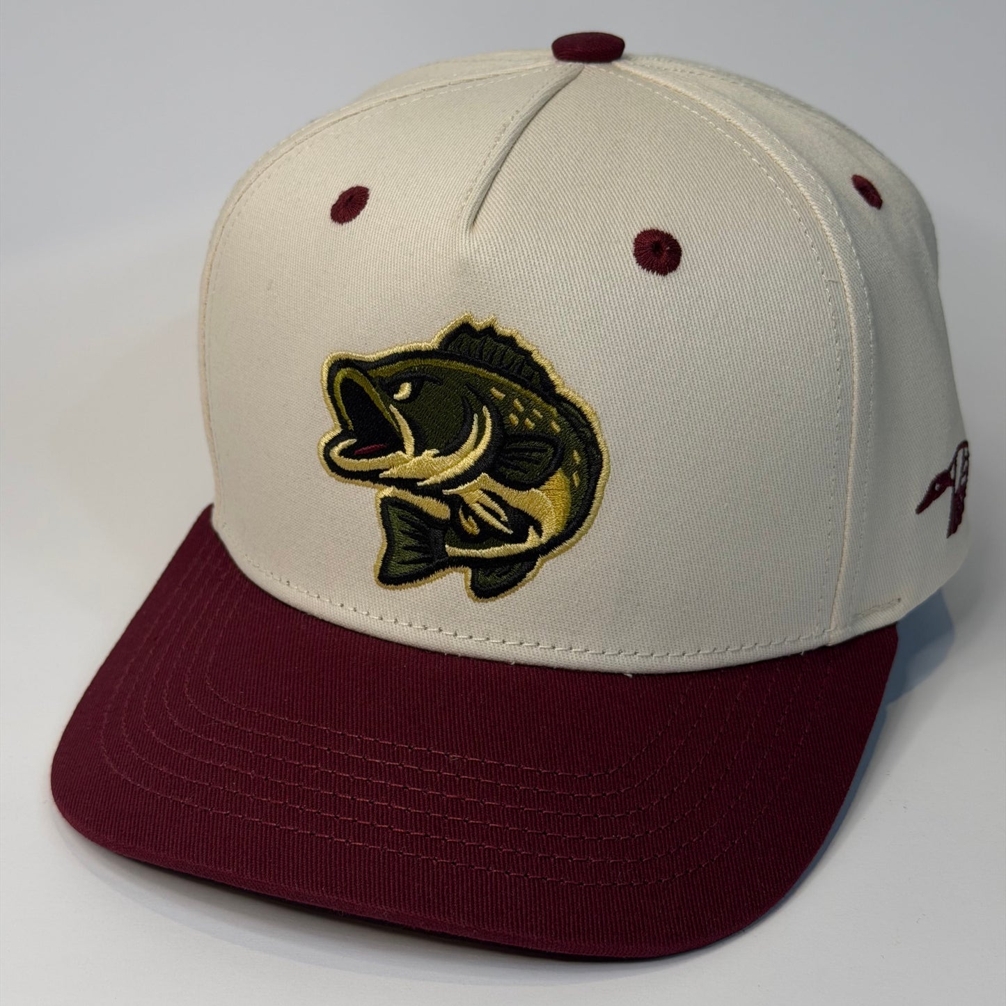 Beige and maroon cap with a fish emblem on a white background