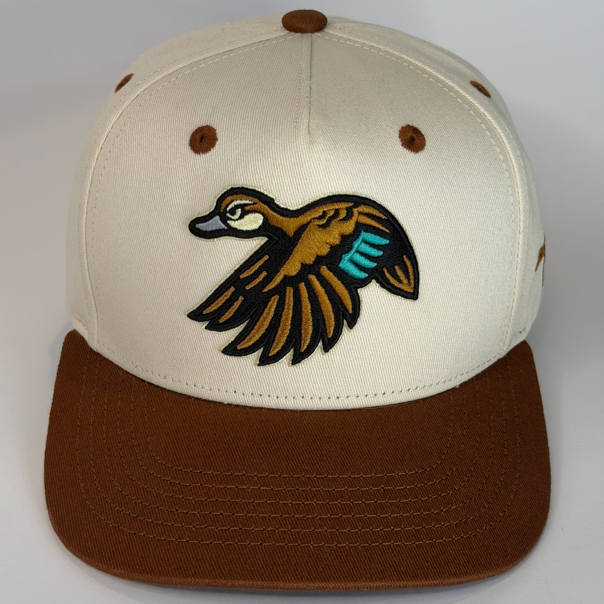 Beige and brown cap with a duck logo on a white background
